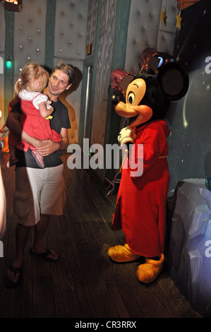 Mickey Mouse grüßt ein schüchternes kleines Mädchen durch ihren Vater in Mickys House Studio in Disneyland, Anaheim, Kalifornien statt Stockfoto