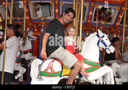 Vater und Tochter reiten weiß auf König Arthurs Karussell-Attraktion im Disneyland Park, Anaheim, Kalifornien Stockfoto