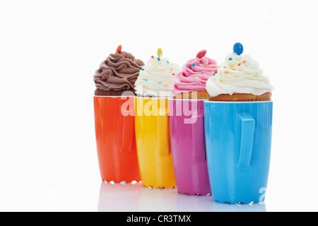 Verschiedene Muffins in bunten Kaffeetassen Stockfoto