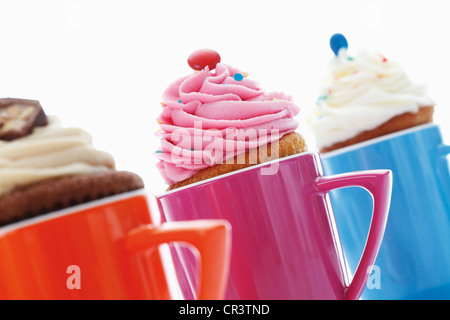 Verschiedene Muffins in bunten Kaffeetassen Stockfoto