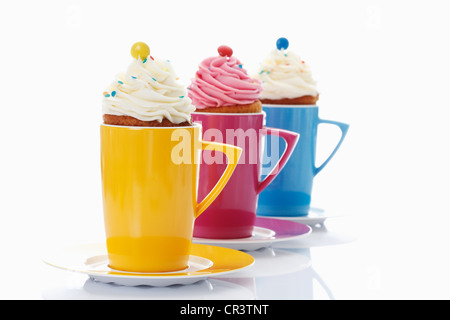 Verschiedene Muffins in bunten Kaffeetassen Stockfoto