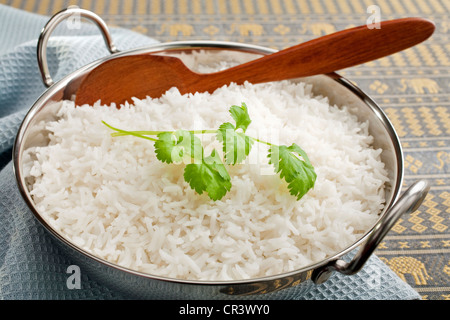 Basmati-Reis in einem Stahl Karahi, garniert mit Koriander, mit einem Holzlöffel. Stockfoto