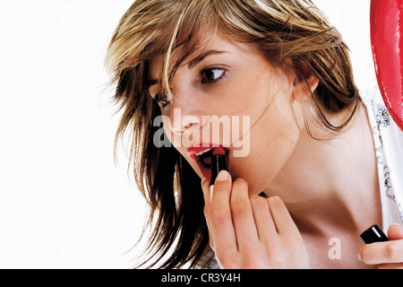 Junge Frau Auftragen von Lippenstift Stockfoto