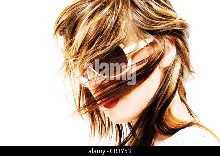 Junge Frau mit Sonnenbrille mit wehenden Haaren Stockfoto
