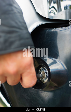 Weibliche Biker mit Zündschlüssel zum Starten eines Motorradmotors Stockfoto