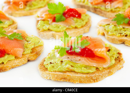 Crostini und Bruschetta mit Guacamole, Räucherlachs und Feuer geröstet, Pfeffer. Stockfoto
