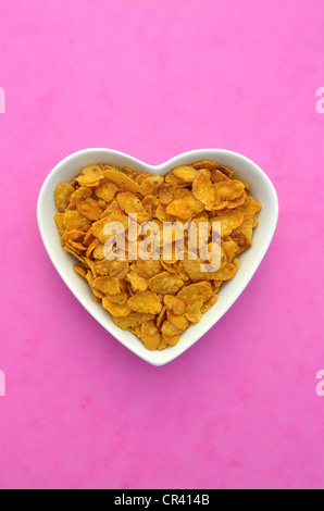 Cornflakes in eine herzförmige Schale aus Porzellan Stockfoto