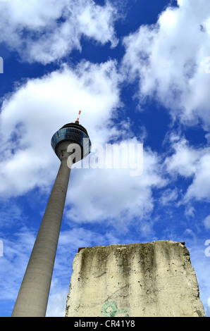 Ein Stück der Berliner Mauer vor dem Turm Rheinturm, Düsseldorf, Nordrhein-Westfalen, Deutschland, Europa Stockfoto