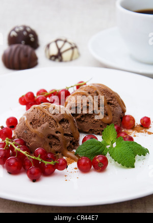 Schokoladeneis mit roten Johannisbeeren und Caramel-topping Stockfoto