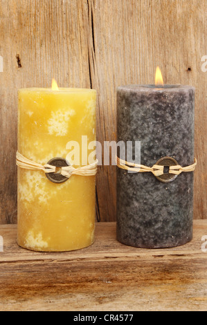 Zwei brennende, die Feng Shui Kerzen vor dem Hintergrund der alten verwitterten Holz Stockfoto