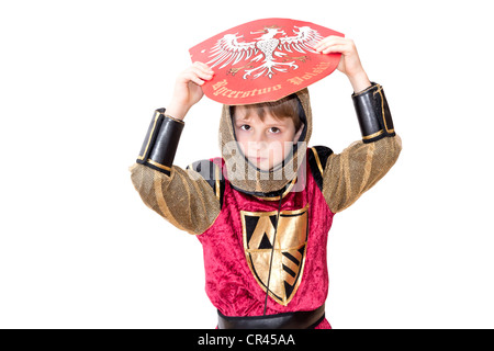 Junge mit Karnevalskostüm. Der kleine kämpfende Ritter mit polnischen Wappen auf dem Schild. Stockfoto