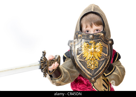 Junge mit Karnevalskostüm. Der kleine kämpfende Ritter mit polnischen Wappen auf dem Schild. Stockfoto