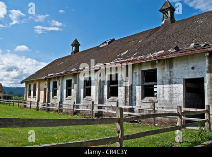 alte verlassene Milchviehbetrieb eine große Scheune mit alten Holz-Zaun, an einem sonnigen Tag in einem horizontalen Format. Stockfoto