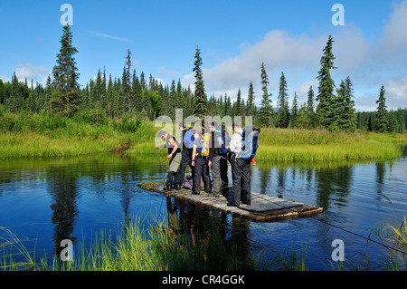 Gruppe von Touristen, die Überquerung eines kleinen Flusses auf einem Kabel Fähre, Kroto Lake, Alaska, USA, Nordamerika Stockfoto
