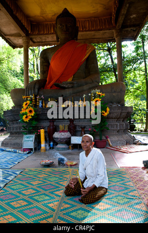 Buddhistische Nonne mit Weihrauch sitzt vor dem Giant Buddha Alter, dem Bayon, Tempel von Angkor, Siem Reap Provinz, Kambodscha. © Kraig Lieb Stockfoto