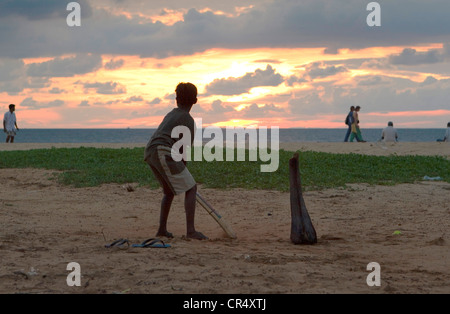 Sri Lankans spielen Cricket im schwindenden Licht des Sonnenuntergangs am Strand von Negombo, Sri Lanka Stockfoto