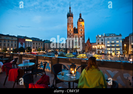 St.-Marien Kirche in der Abenddämmerung vom Terrassen-Café auf den Tuchhallen, Frau sitzt am Tisch gesehen Stockfoto