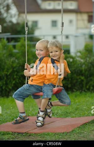 Zwei kleine Jungs, 3 und 4 Jahren auf einer Schaukel Stockfoto