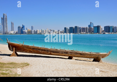 Holzboot im Heritage Village, vor der Skyline von Abu Dhabi, Vereinigte Arabische Emirate, Arabische Halbinsel, Asien Stockfoto