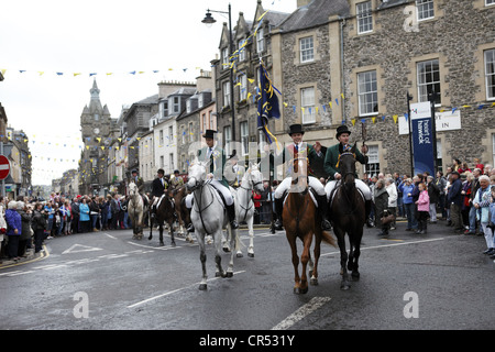 Das Kornett und seine Anhänger reitet auf ihrer Prozession durch die Stadt während Hawick Common-Reiten in der Grenzstadt, Schottland Stockfoto