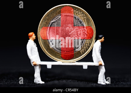 Ein-Euro-Münze als Patient auf einer Bahre, getragen von Miniaturfiguren, symbolisches Bild für die Euro-Krise Stockfoto