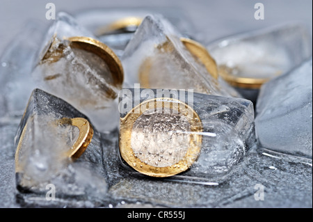 Ein-Euro-Münzen in Eiswürfel, symbolisches Bild für Einfrieren von Geldern Stockfoto