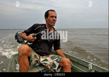 Fischer in seinem kleinen Boot mit einem Außenbordmotor in Sepitiba Bay, seit dem Bau der TKCSA Stahlwerk von Stockfoto