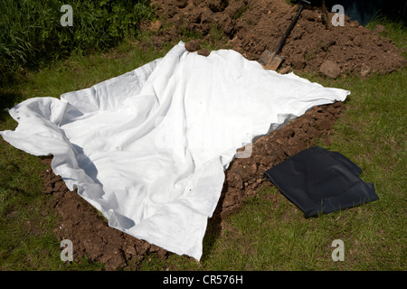 Fleece Futter ein Loch gegraben, um einen Teich im Garten in der uk-w zu errichten Stockfoto