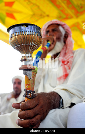 Ältere Mann mit weißem Bart, Rauchtabak in einer traditionellen Pfeife, Wasserpfeife, Muzaffaragarh, Punjab, Pakistan, Asien Stockfoto