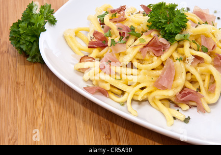 Käse-Spätzle mit Petersilie auf hölzernen Hintergrund Stockfoto