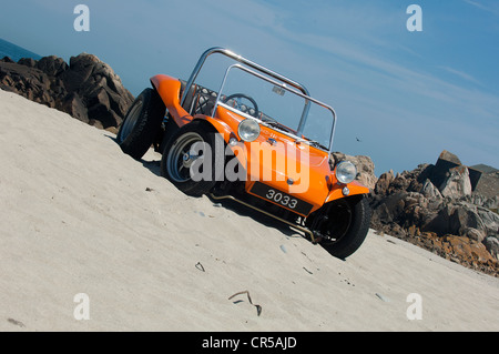 VW Strandbuggy auf einem sandigen Strand unter blauem Himmel Stockfoto