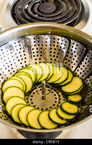 In Scheiben geschnittenen Zucchini in einen Dämpfeinsatz in einem Topf Stockfoto