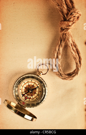 Vintage-Kompass Top Schuss über einen trashigen gelbes Papier Stockfoto