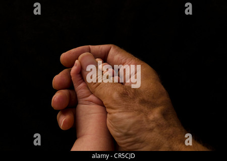 Hand des Vaters des Kindes Hand hält Stockfoto