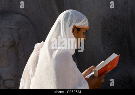 Jain-Pilger ist rezitieren religiöser Texte an den Füßen der riesigen Statue von Gomateshwara in Indien, Asien Stockfoto