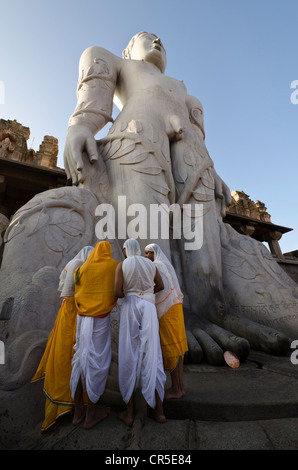 Eine Gruppe von Jain Pilgern tun eine spezielle Pooja die Segnungen von Bahubali von den lokalen Priestern vor der statue Stockfoto