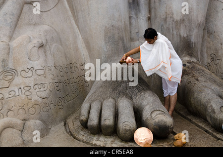 Jain Pilger gießt Wasser über den Füßen der Statue von Lord Gomateshwara, der größte monolithische Statue der Welt, Stockfoto