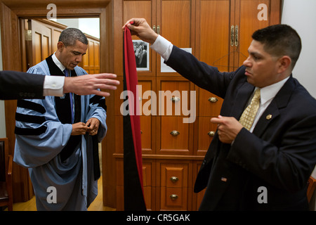 US-Präsident Barack Obama wird unterstützt von Kammerdiener Paul Reyna, rechts, mit seinem akademischen Roben geben, bevor das Barnard College-Abschlussfeier auf dem Campus der Columbia University 14. Mai 2012 in New York, NY. Stockfoto