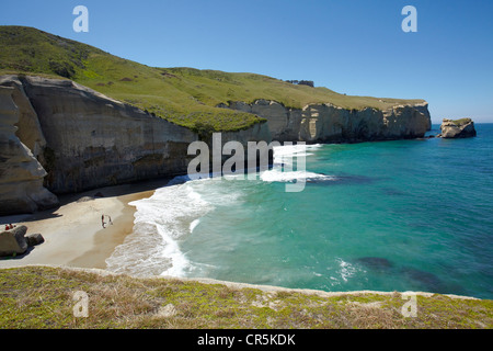 Touristen am Strand und Klippen am Tunnel Beach, Dunedin, Südinsel, Neuseeland Stockfoto