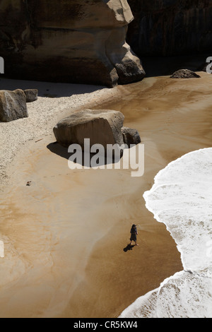 Touristen am Strand und Klippen am Tunnel Beach, Dunedin, Südinsel, Neuseeland Stockfoto