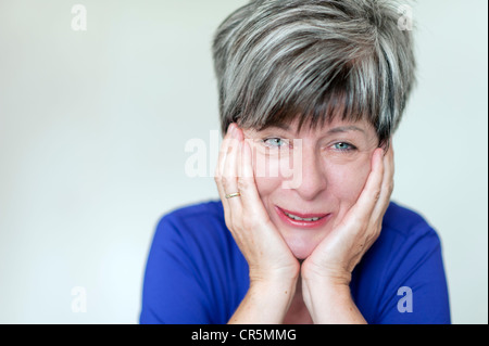 Frau, 50 +, den Kopf mit den Händen zu unterstützen und zu weinen, Porträt Stockfoto