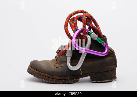 Alten Bergschuhe mit genagelten Sohlen und Absätzen von Eisen, mit einem Kletterseil und Karabiner Stockfoto