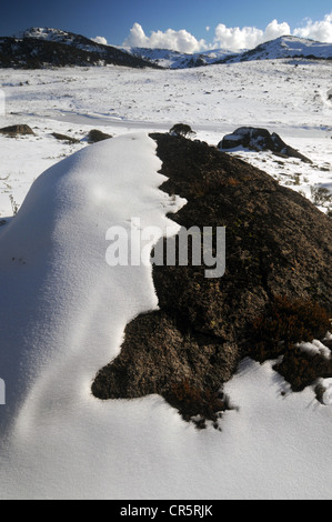 Schnee auf Felsbrocken, mit Mt Kosciuszko-Gipfel im Hintergrund, Kosciuszko National Park, NSW, Australien Stockfoto