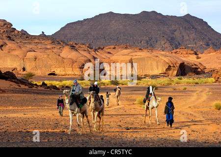 Gruppe von abenteuerlustigen Touristen auf Kamelen auf einen Ausflug in das Akkakus-Gebirge, Sahara, Libyen, Afrika Stockfoto