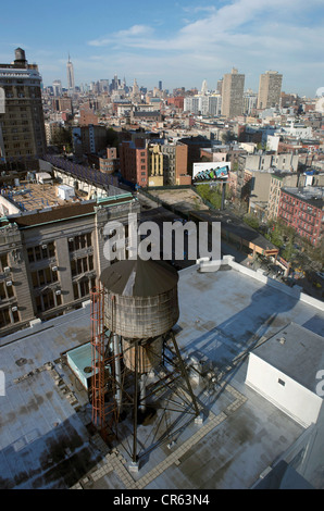 Vereinigte Staaten, New York City, Manhattan, Soho, Gebäude mit Wassertank und Empire State Building im Hintergrund Stockfoto