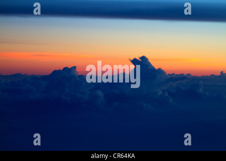 Blick auf den Sonnenuntergang über den Wolken von Flugzeugfenster gesehen Stockfoto