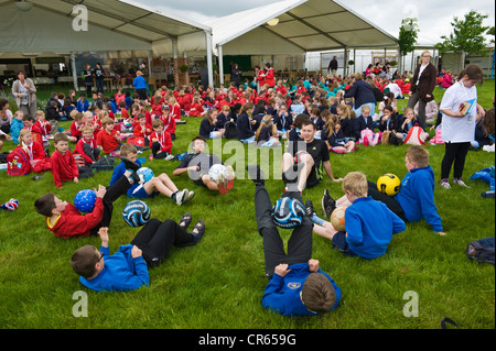 Schülerinnen und Schüler aus Schulen der Powys und Herefordshire genießen Sie ein Mittagessen auf dem Festival Rasen und üben ihre fußballerischen Fähigkeiten in The Telegraph Hay Festival, Hay-on-Wye, Powys, Wales, UK Stockfoto