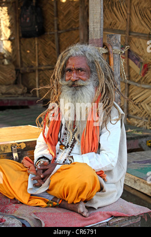 Sadhu, ein indischer heiligen Mann Wandern, sitzen neben den Fluss Ganges, Garhmukteshwar, Uttar Pradesh, Nordindien, Indien, Asien Stockfoto