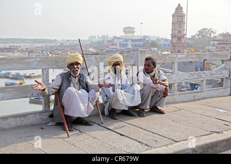 Drei Männer sitzen neben den Fluss Ganges, Garhmukteshwar, Uttar Pradesh, Nordindien, Indien, Asien Stockfoto