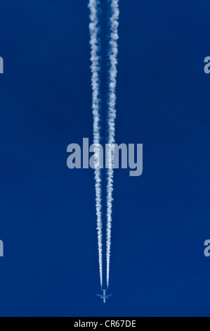 Flugzeuge mit zwei Kondensstreifen vor blauem Himmel Stockfoto